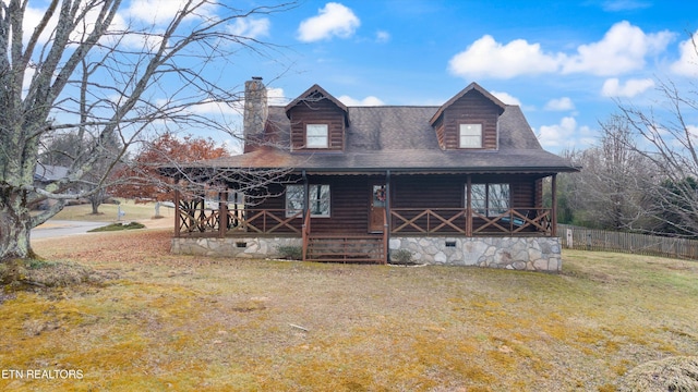 log-style house with a porch and a front lawn