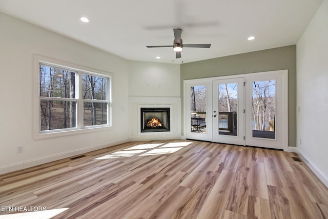 unfurnished living room with ceiling fan and light hardwood / wood-style floors