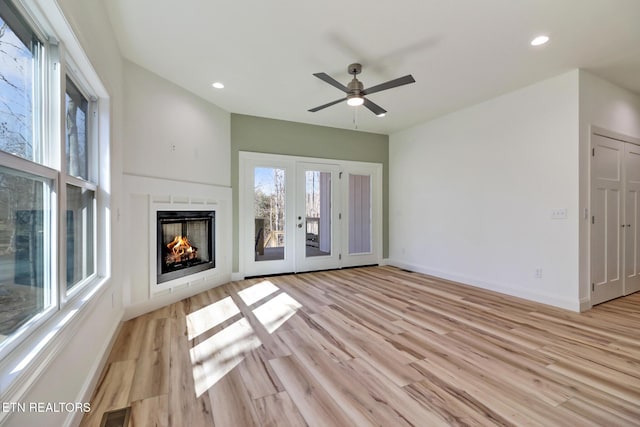 unfurnished living room with light hardwood / wood-style flooring, french doors, and ceiling fan