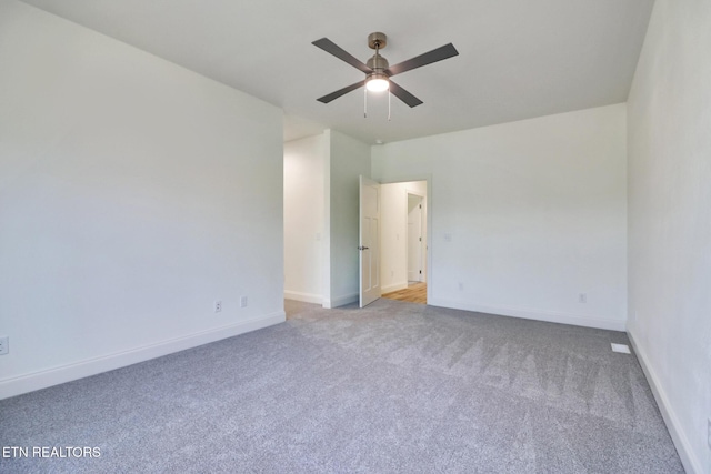 carpeted spare room featuring ceiling fan