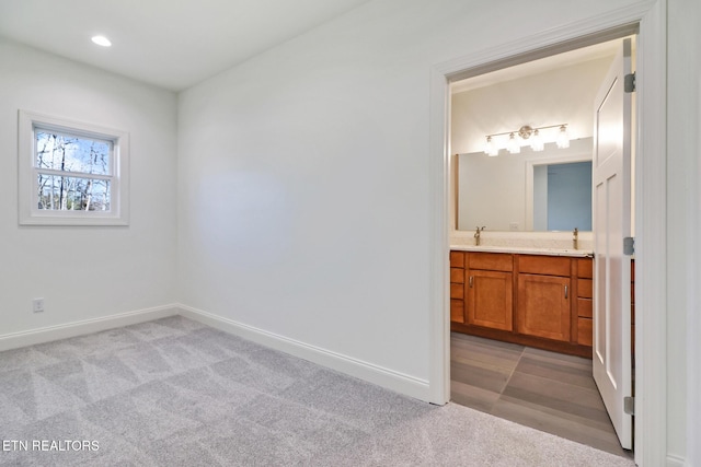 bedroom with connected bathroom and light colored carpet