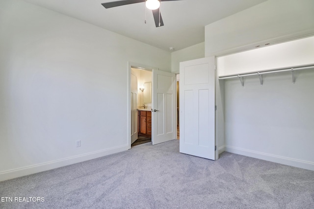 unfurnished bedroom featuring ceiling fan, light colored carpet, ensuite bathroom, and a closet