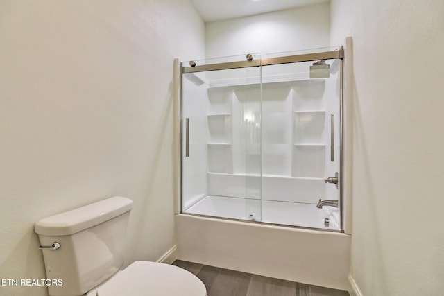 bathroom with wood-type flooring, toilet, and combined bath / shower with glass door