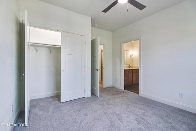 unfurnished bedroom featuring light carpet, connected bathroom, sink, and a closet