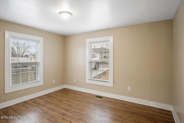 1231 Jefferson Ave, Maryville, TN 37804 - unfurnished room featuring baseboards, wood finished floors, visible vents, and a healthy amount of sunlight