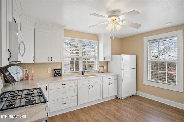 1231 Jefferson Ave, Maryville, TN 37804 - kitchen featuring light wood finished floors, white cabinets, a sink, white appliances, and baseboards