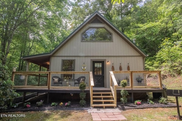 rear view of house featuring a wooden deck