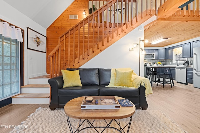 living room with a towering ceiling and light hardwood / wood-style floors