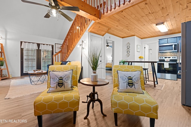 living area featuring light hardwood / wood-style flooring, vaulted ceiling, ceiling fan, crown molding, and wooden ceiling