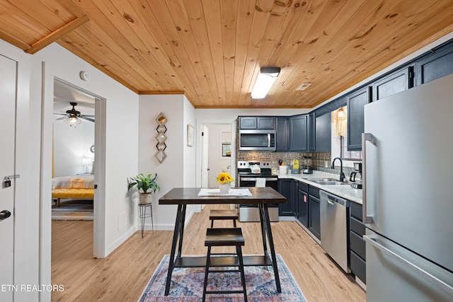 kitchen with appliances with stainless steel finishes, tasteful backsplash, light hardwood / wood-style floors, wood ceiling, and sink