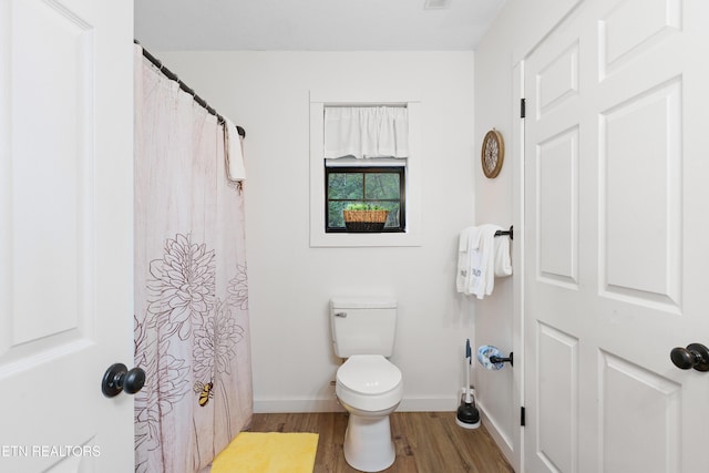 bathroom featuring toilet and wood-type flooring