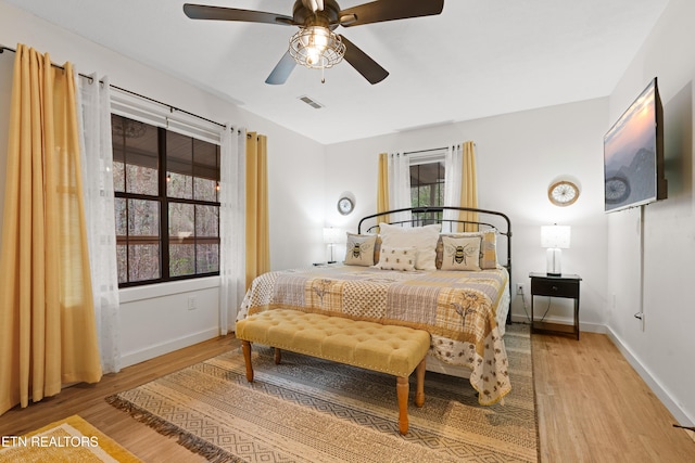 bedroom featuring multiple windows, ceiling fan, and light hardwood / wood-style flooring