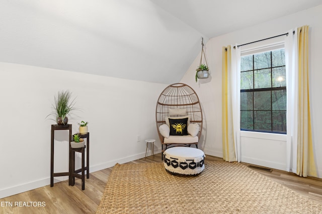 living area with vaulted ceiling and light hardwood / wood-style flooring