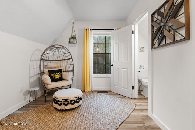 living area featuring light wood-type flooring and vaulted ceiling