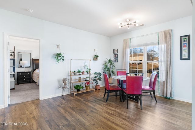 dining area with an inviting chandelier and dark hardwood / wood-style flooring