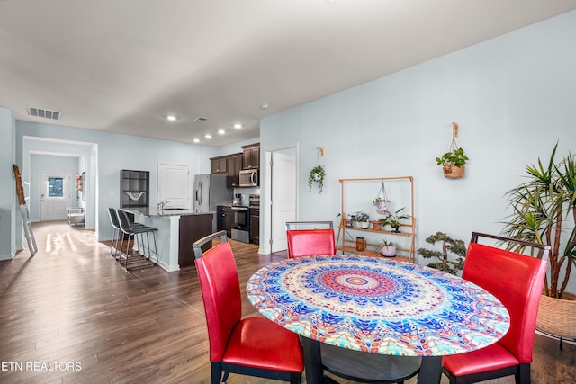 dining space featuring dark wood-type flooring and sink