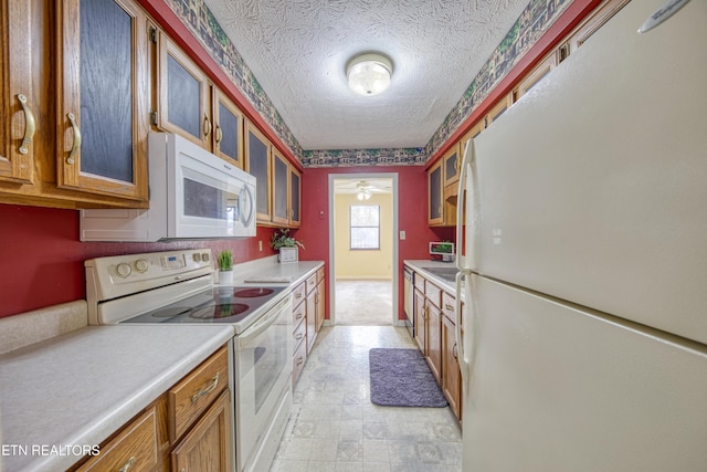 kitchen featuring white appliances and a textured ceiling