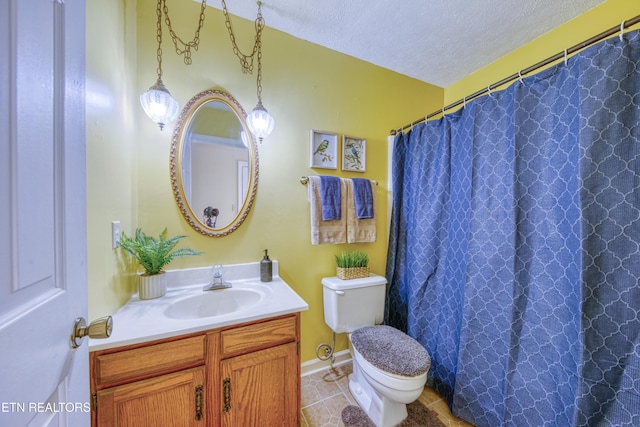 bathroom featuring vanity, tile patterned floors, a textured ceiling, and toilet