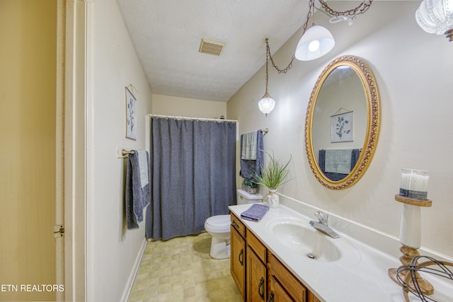 bathroom with vanity, toilet, a textured ceiling, and walk in shower