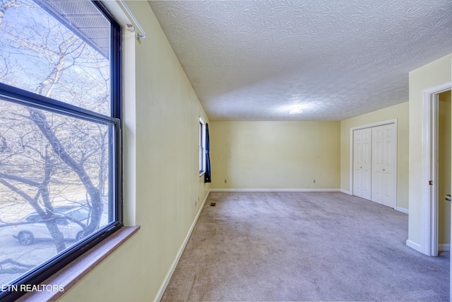 unfurnished bedroom featuring a closet, light carpet, and a textured ceiling