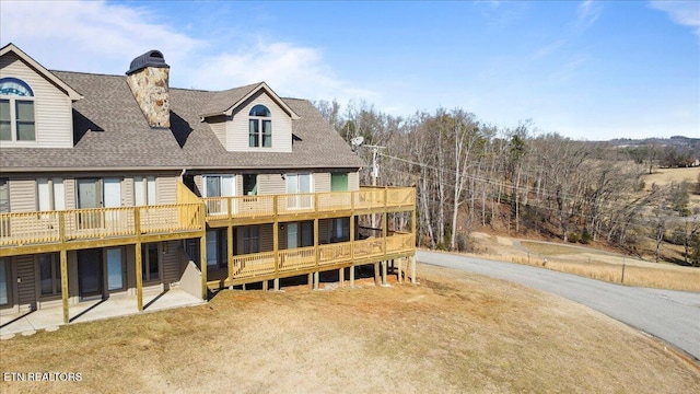 back of house with a wooden deck and a patio