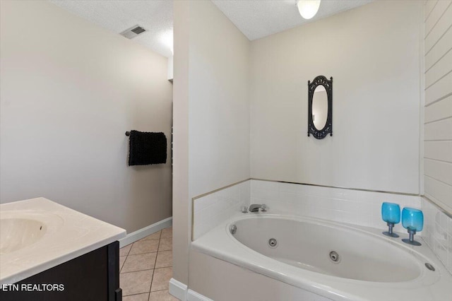 bathroom with vanity, tile patterned floors, a tub, and a textured ceiling