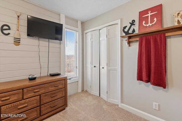 carpeted bedroom with a closet and a textured ceiling