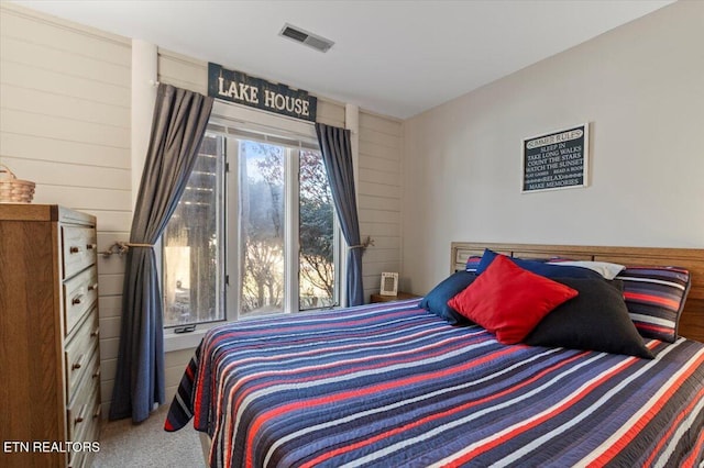 bedroom featuring carpet floors and wooden walls