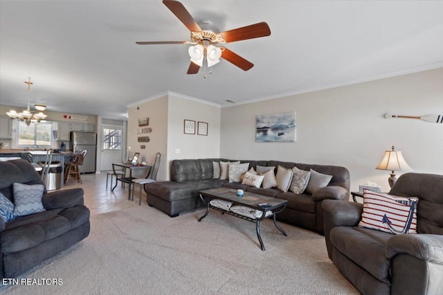 living room with crown molding, ceiling fan with notable chandelier, and light carpet