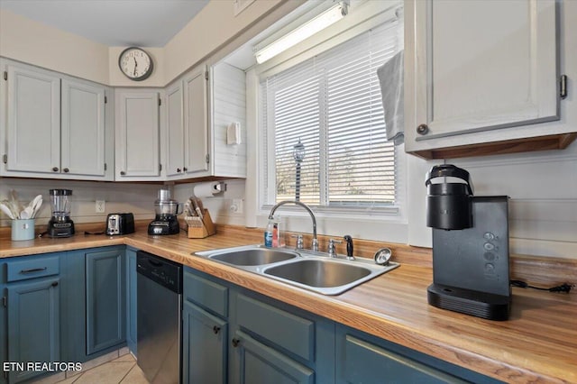 kitchen featuring blue cabinets, white cabinetry, sink, and stainless steel dishwasher