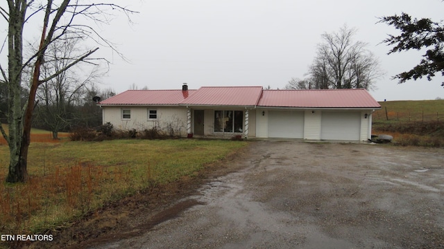 single story home with a garage and a front lawn