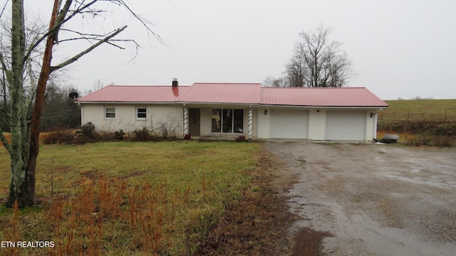 ranch-style home featuring a garage and a front lawn