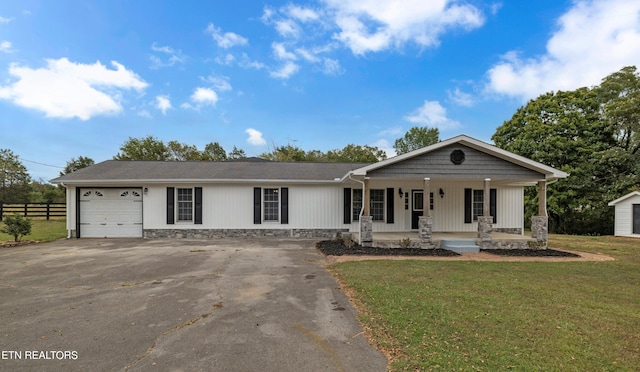 ranch-style home with a garage, covered porch, and a front lawn