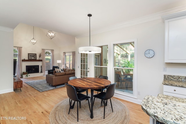 dining room with crown molding, vaulted ceiling, french doors, and light wood-type flooring