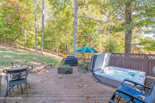 wooden deck with an outdoor hot tub and a grill