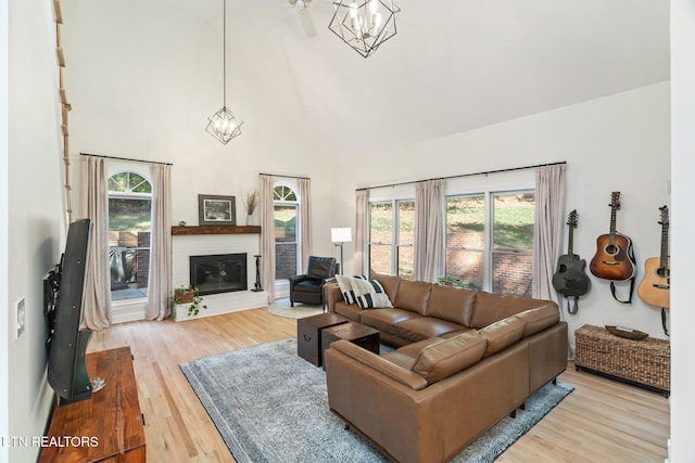 living room with plenty of natural light, a chandelier, and light wood-type flooring