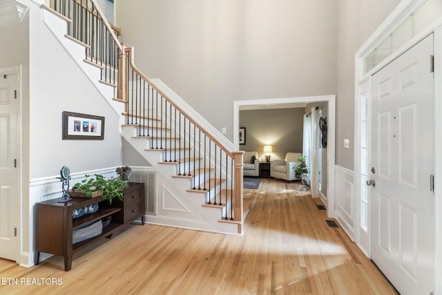 entrance foyer featuring a towering ceiling and hardwood / wood-style floors