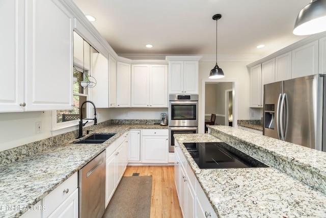 kitchen featuring pendant lighting, sink, white cabinets, and appliances with stainless steel finishes