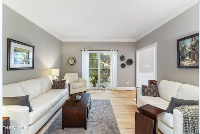 living room with ornamental molding and light hardwood / wood-style floors