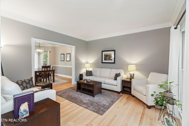 living room featuring crown molding, wood-type flooring, and an inviting chandelier