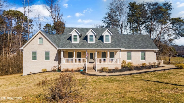 cape cod-style house with covered porch and a front yard