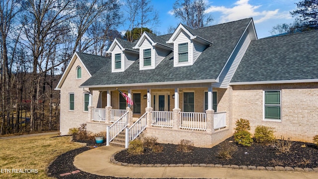 cape cod house featuring covered porch