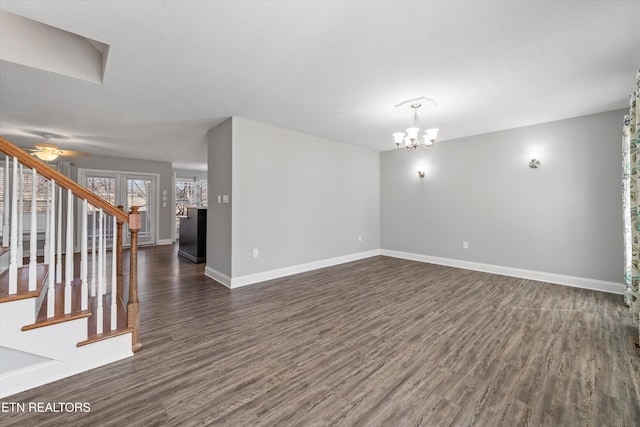 unfurnished living room featuring ceiling fan with notable chandelier and dark hardwood / wood-style floors