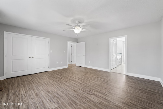 unfurnished bedroom featuring ceiling fan, a closet, connected bathroom, and light hardwood / wood-style flooring