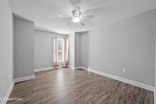 spare room with ceiling fan, a textured ceiling, and dark hardwood / wood-style flooring