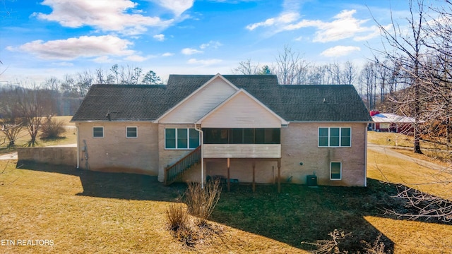 rear view of property featuring a sunroom, central AC, and a lawn