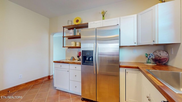 kitchen with white cabinets, wood counters, and stainless steel fridge with ice dispenser