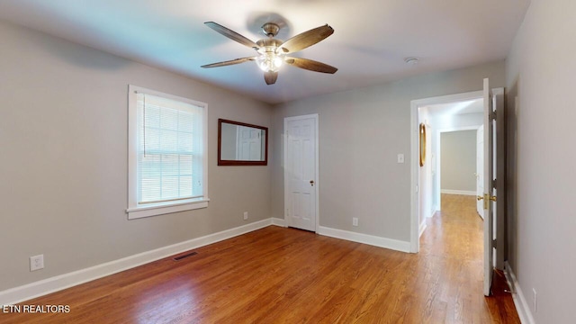 unfurnished bedroom featuring ceiling fan, a closet, and light wood-type flooring