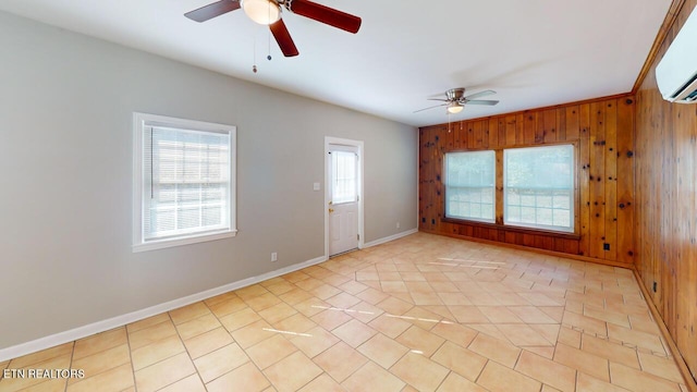 unfurnished room with ceiling fan, wooden walls, a wall mounted AC, and light tile patterned flooring