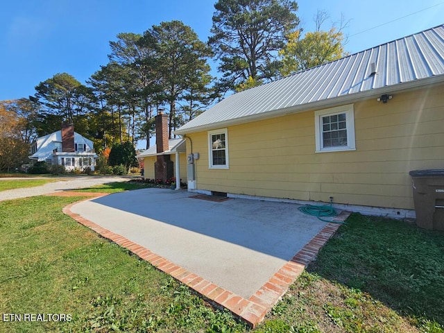 view of home's exterior with a yard and a patio area